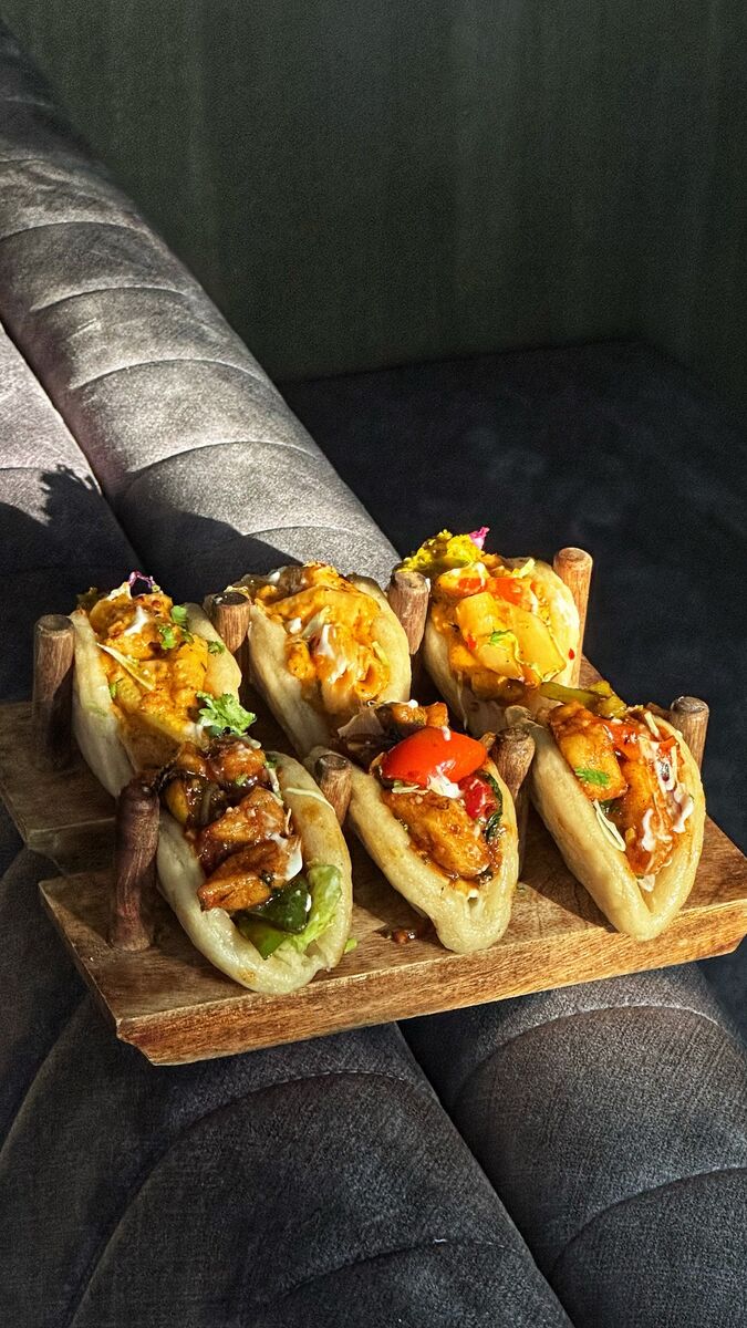 Vegetarian bao buns served on a board at EMC Kitchen in Vesu, Surat